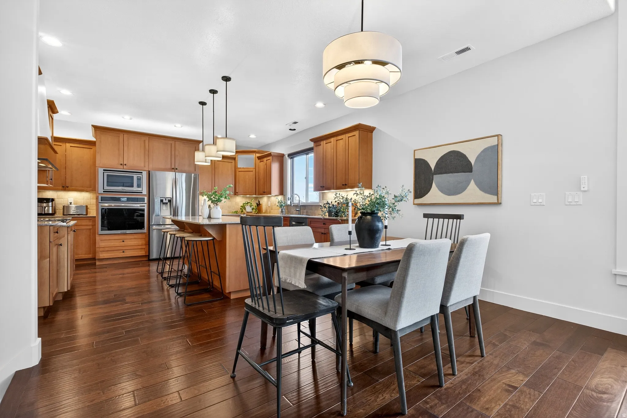 Dining room with dark wood finished floors and recessed lighting