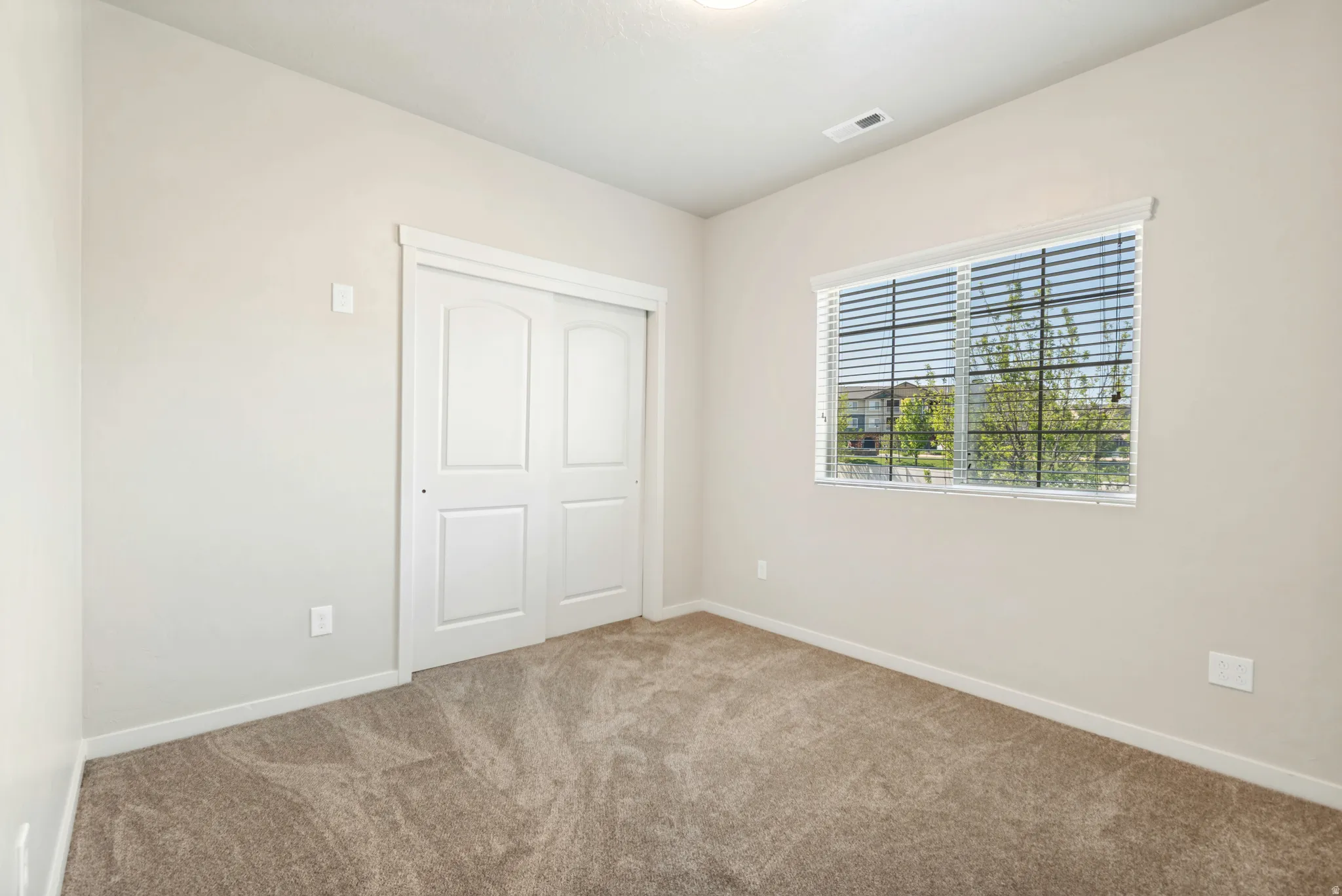 Neutral-toned walls complement plush carpeting