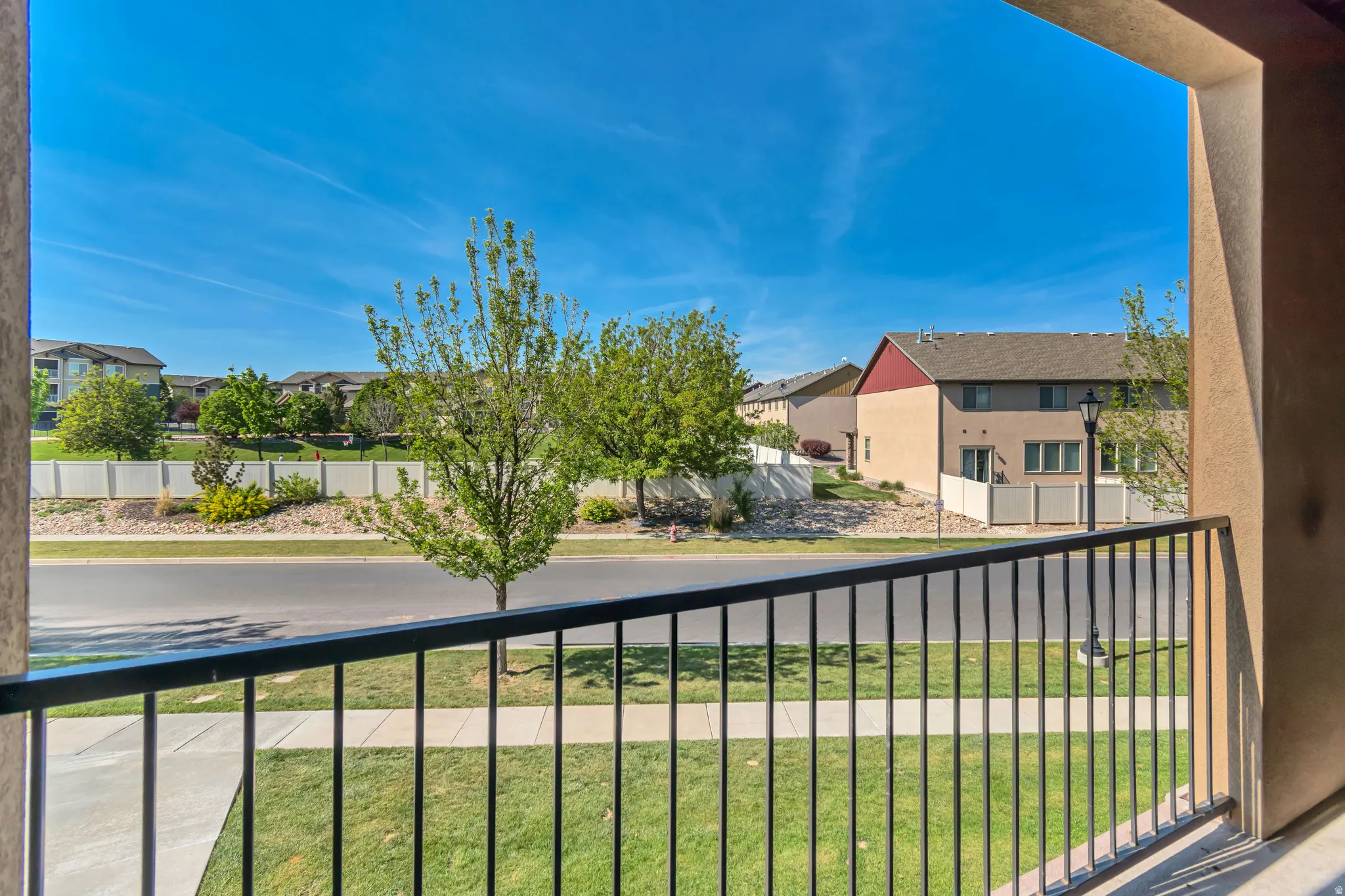 Balcony featuring a black metal railing, concrete flooring, and stucco siding