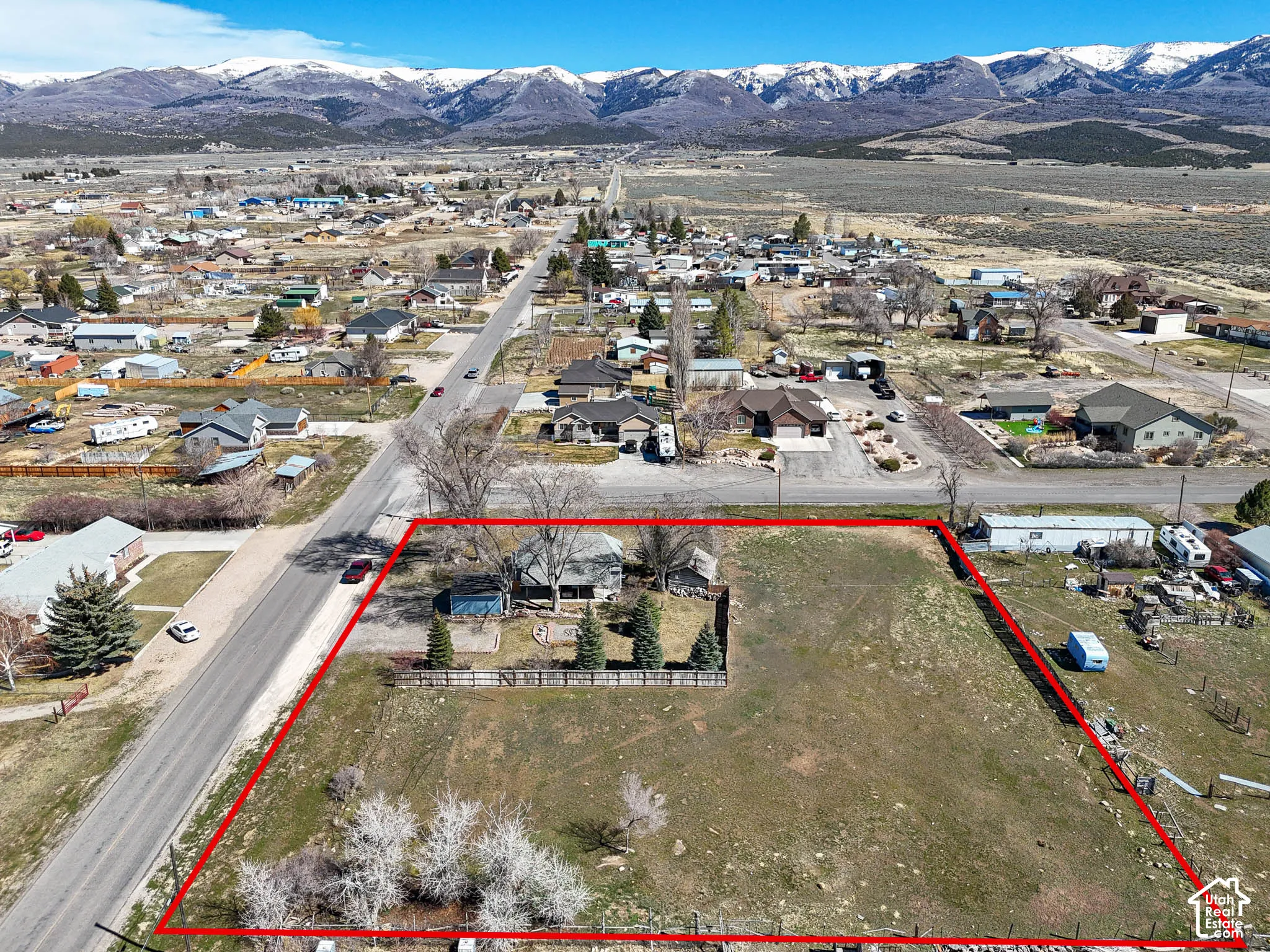 Expansive lot featuring mature trees, a fenced perimeter, and unobstructed mountain scenery