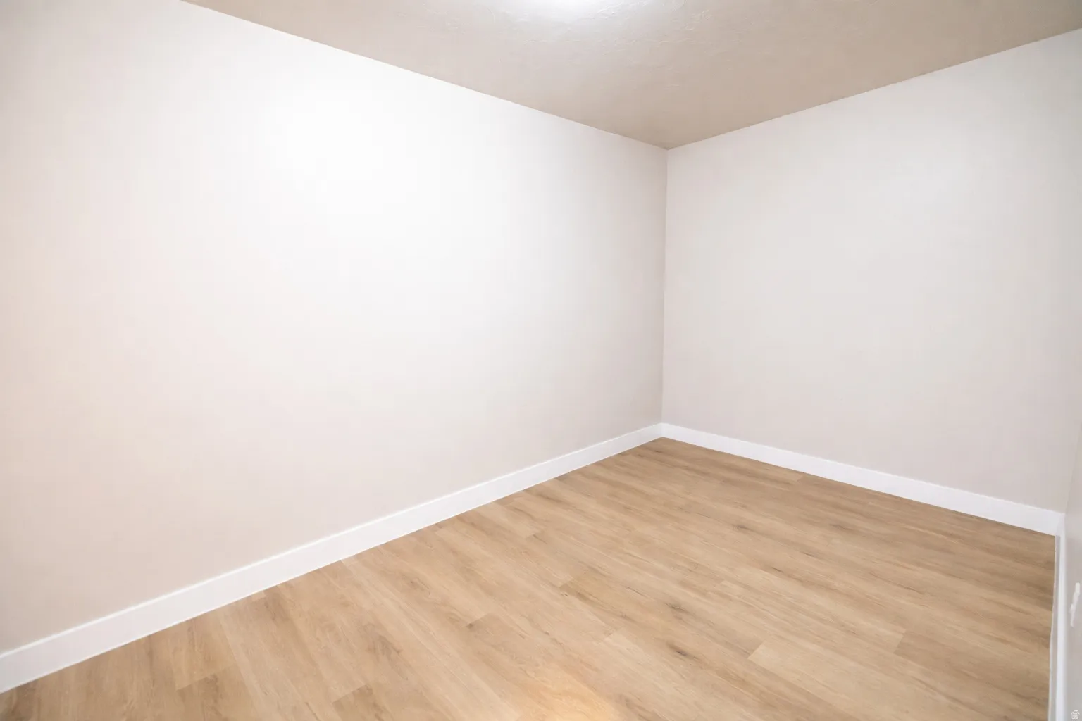 Empty room featuring baseboards and light wood-style floors