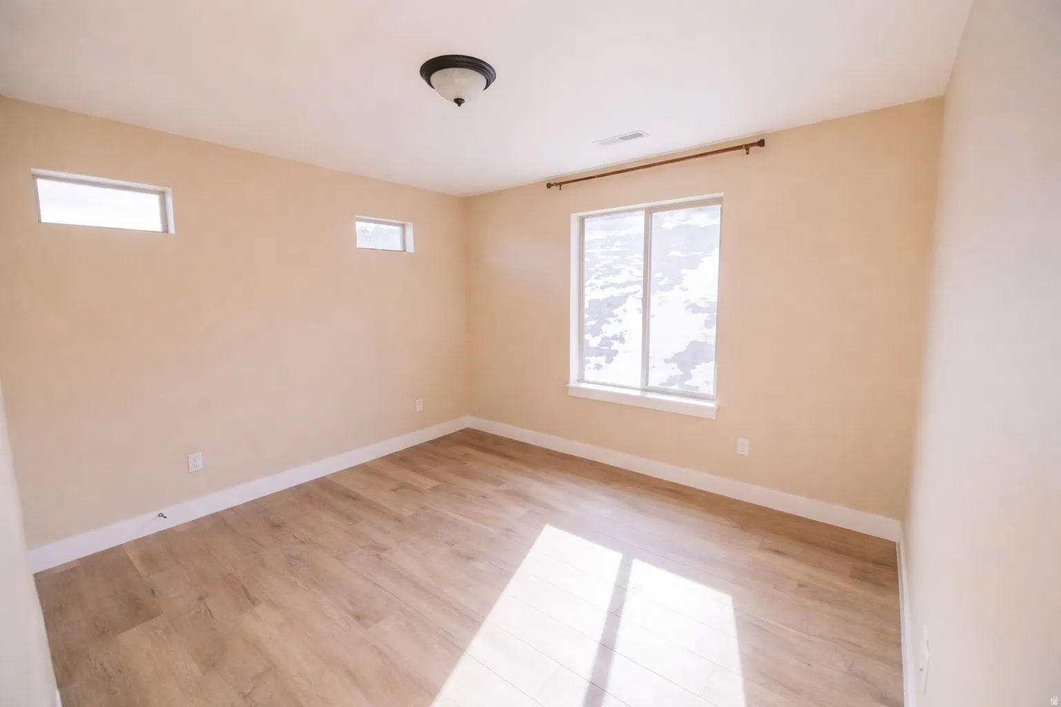 Spare room with light wood-style flooring and baseboards