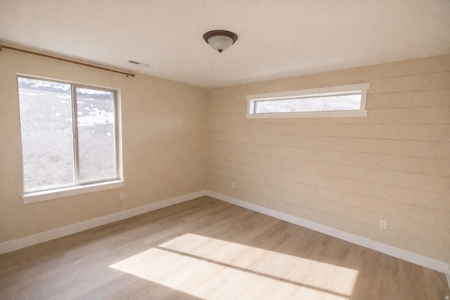 Spare room with light wood-type flooring and baseboards