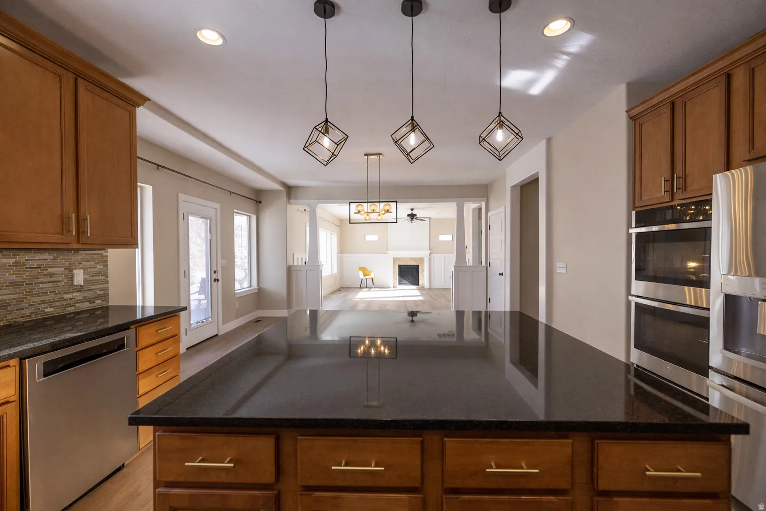 Kitchen with wood finish cabinets, stainless steel appliances, tasteful backsplash, and a fireplace