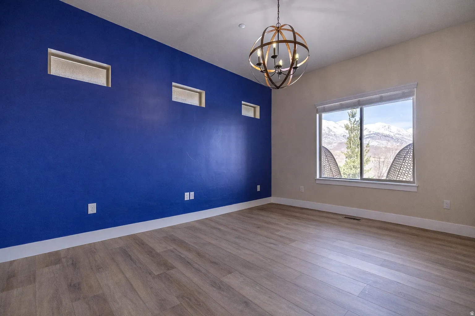 Office or den with mountain views, accent wall, modern chandelier, and luxury vinyl plank flooring