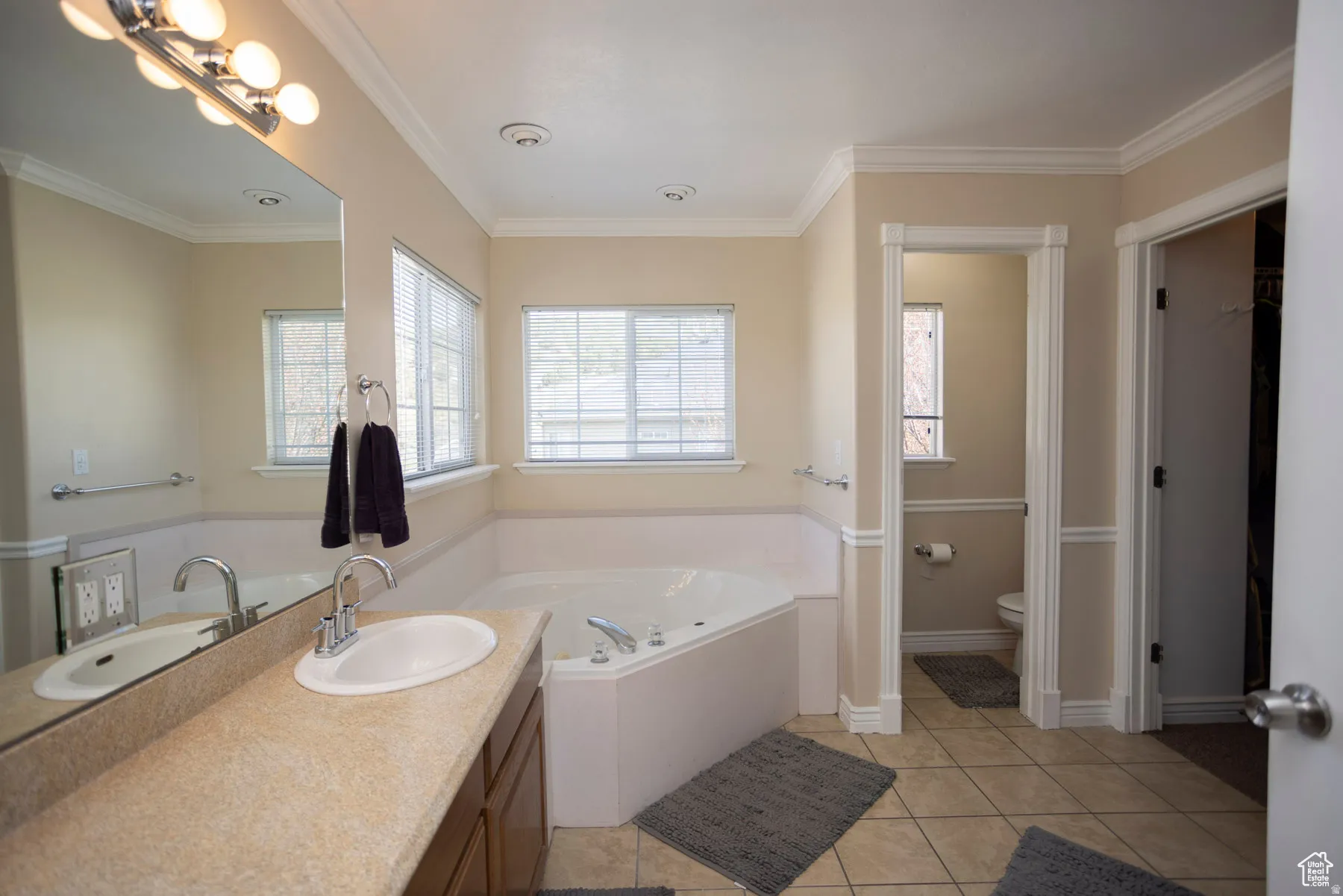 Primary Bedroom Full bathroom featuring vanity, light tile patterned floors, a garden tub, and ornamental molding