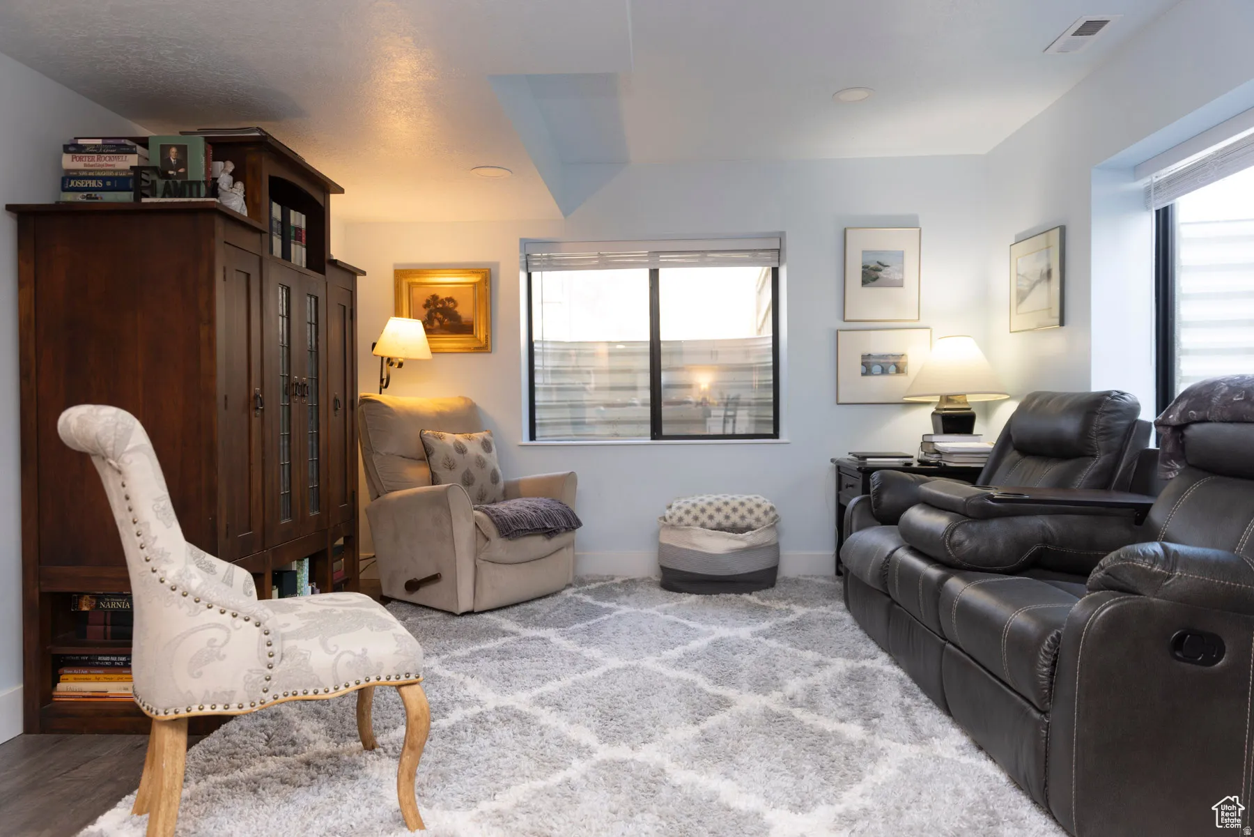 Living area with plenty of natural light and carpet.