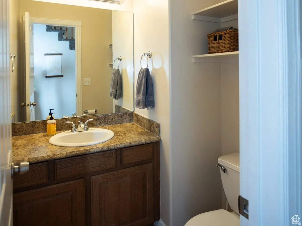 Main Floor Half bath featuring vanity and toilet