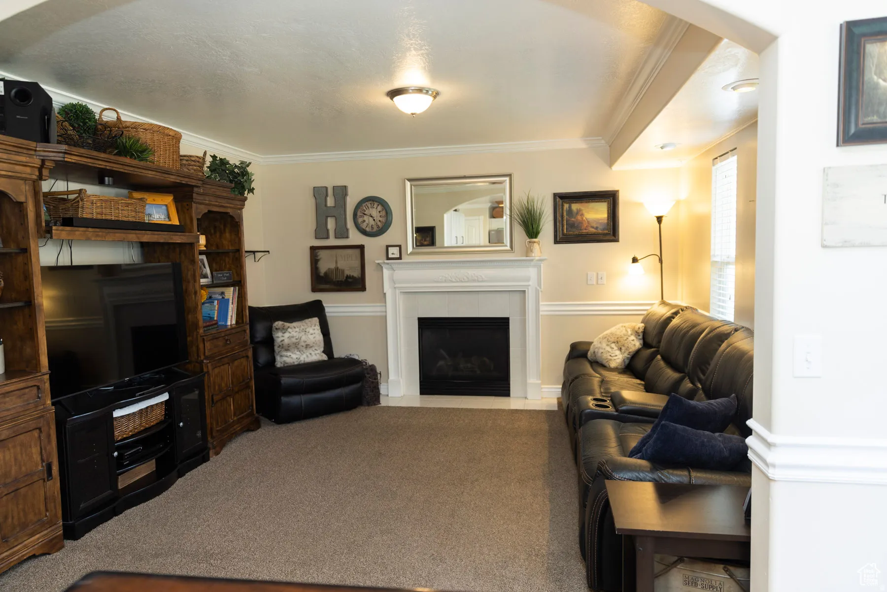 Main Floor Family room with crown molding, a fireplace, and carpet flooring. open to dining and kitchen