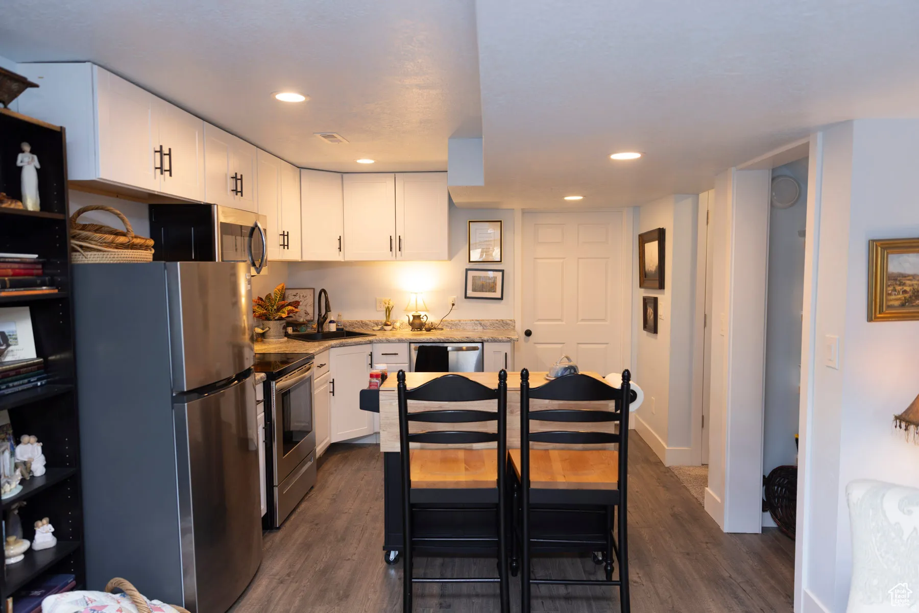 Kitchen with stainless steel appliances, white cabinetry, recessed lighting, and dark wood finished floors