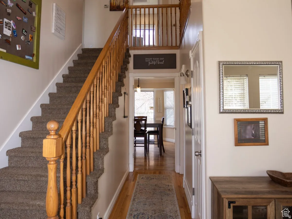 Stairway featuring wood finished floors and a high ceiling