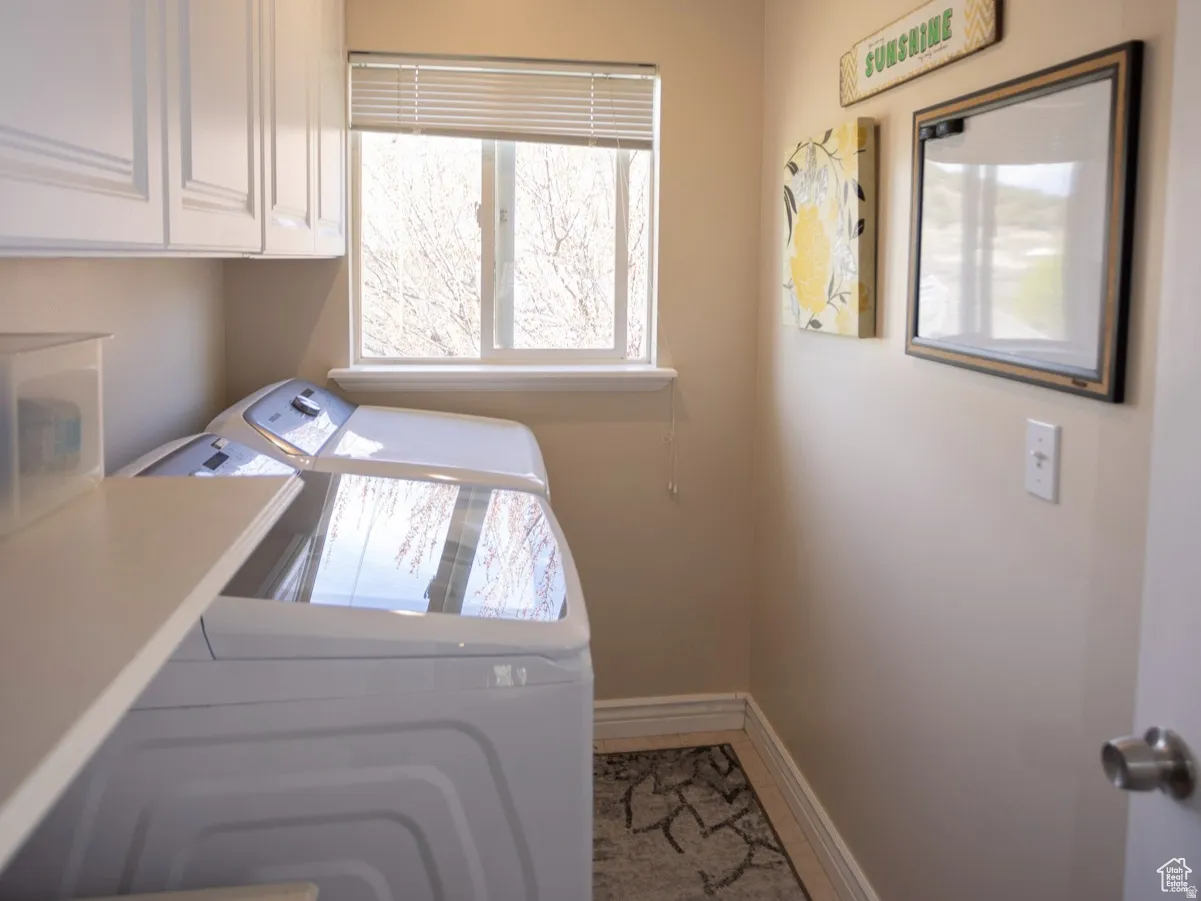 Laundry room with separate washer and dryer and cabinet space