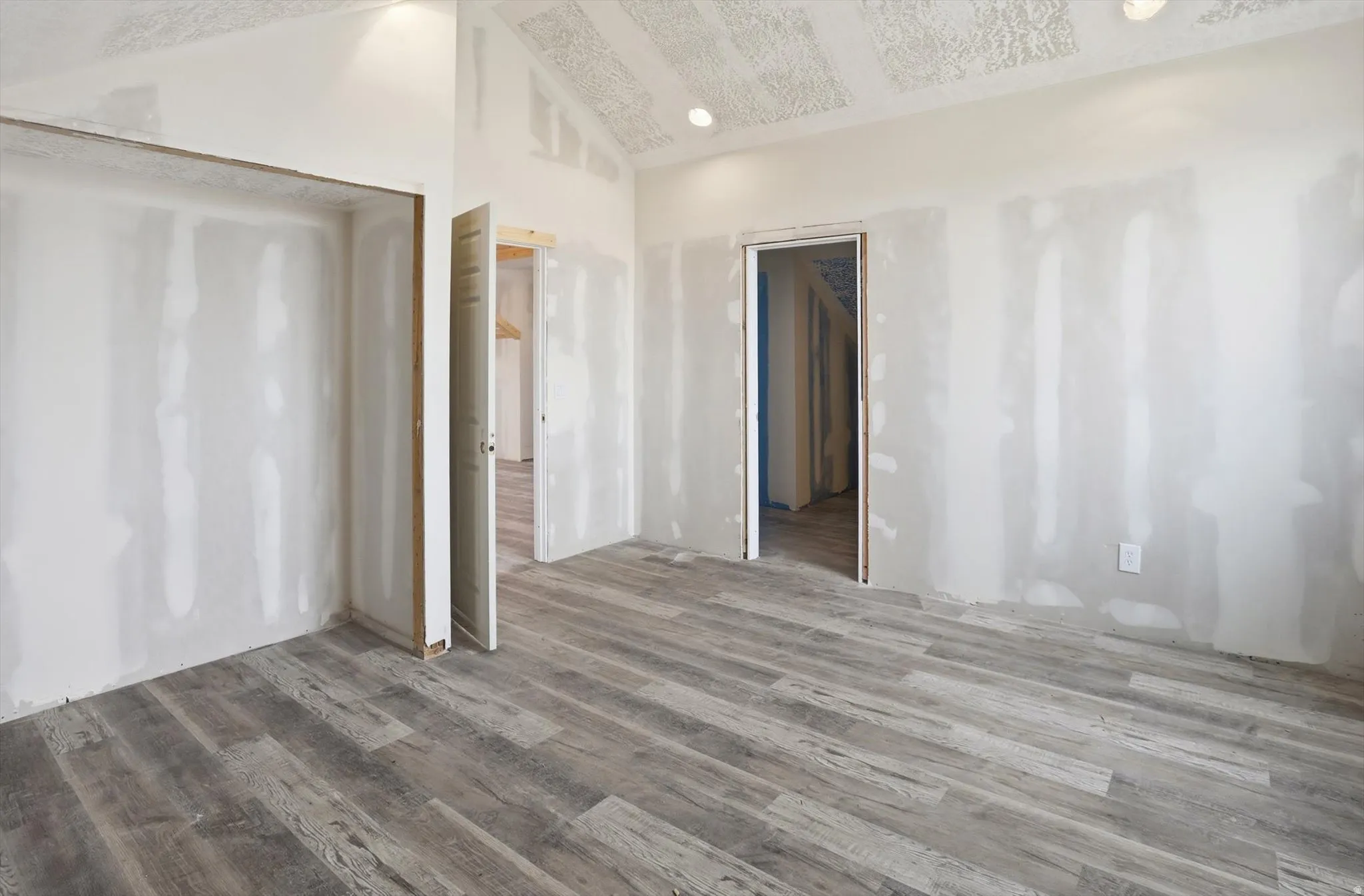 Unfurnished room featuring light wood-style flooring, recessed lighting, and vaulted ceiling