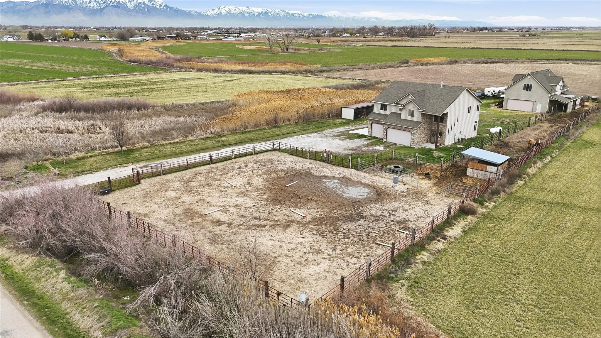 View of horse arena, home, and workshop/ADU and horse stalls.