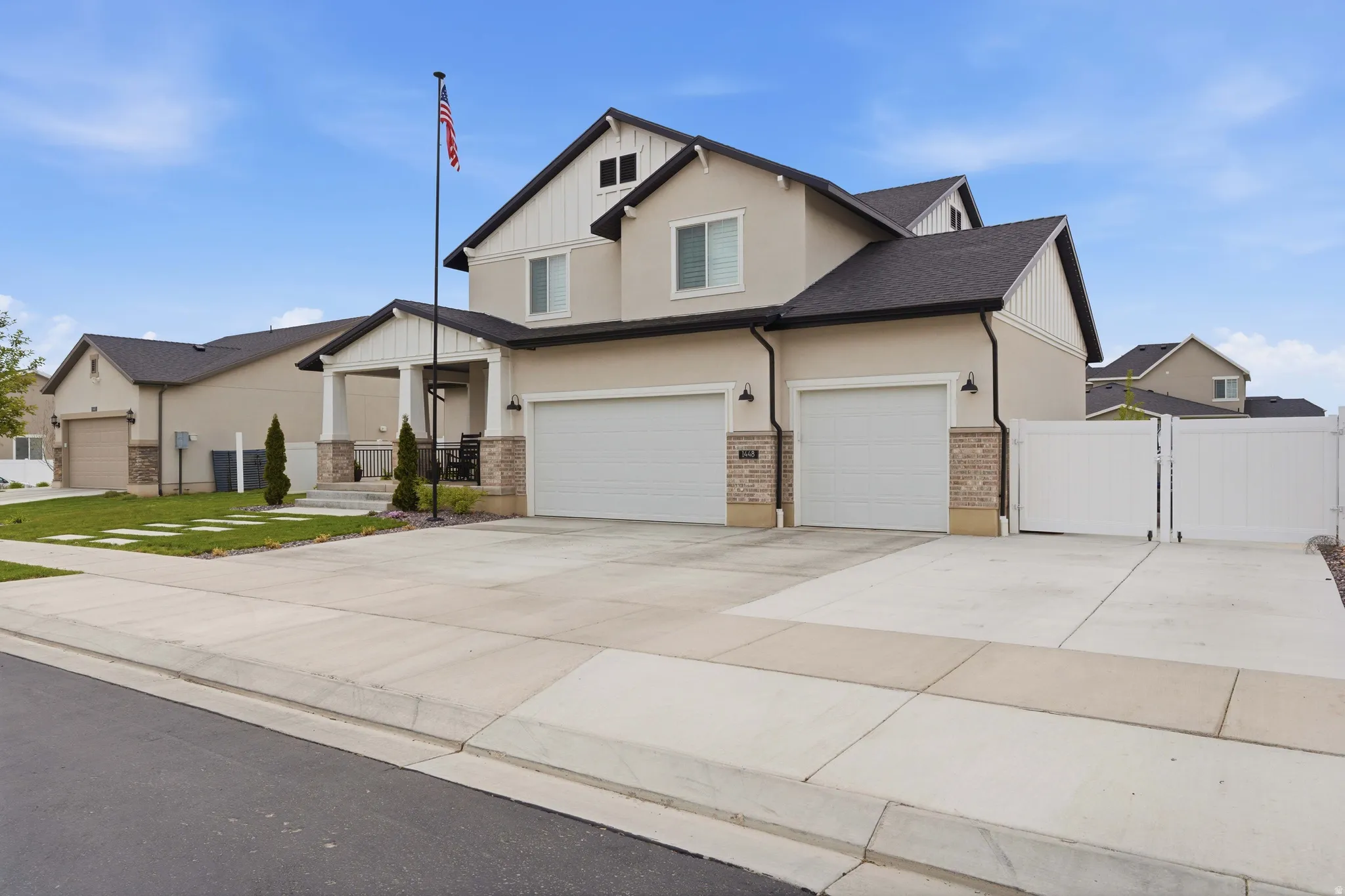 View of front of property with a gate, driveway, an attached garage, stucco siding, and a porch