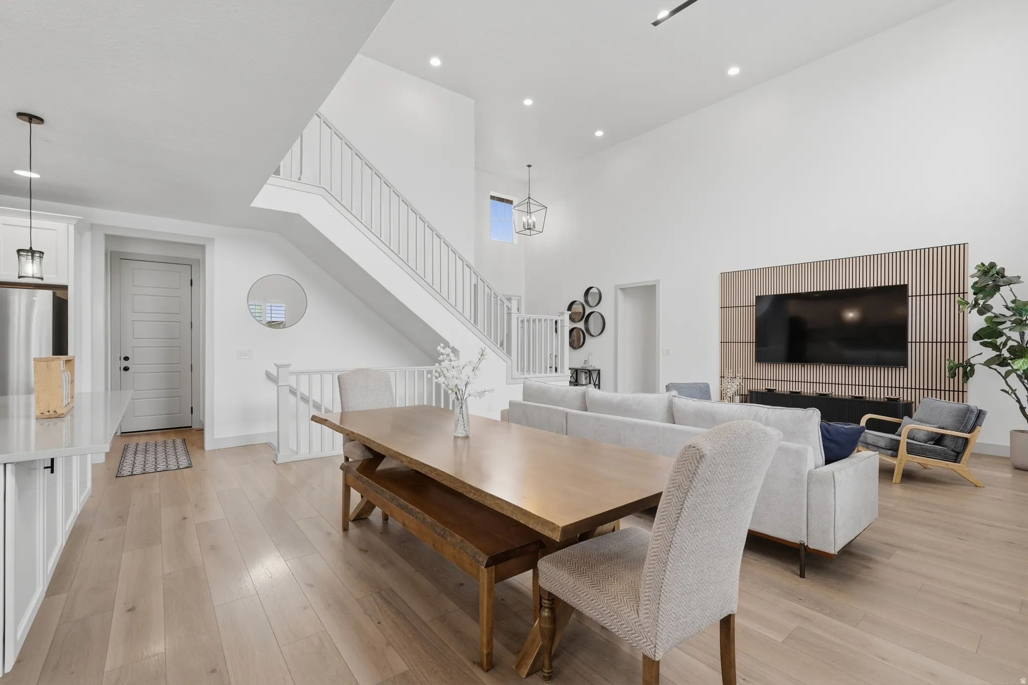 Dining space featuring light wood-style floors and a high ceiling