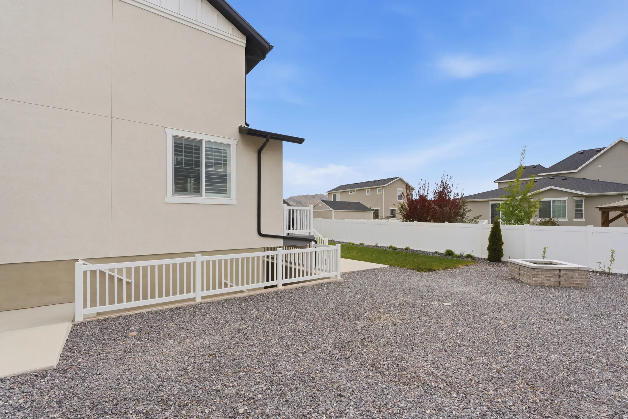 Fenced backyard with a residential view and an outdoor fire pit