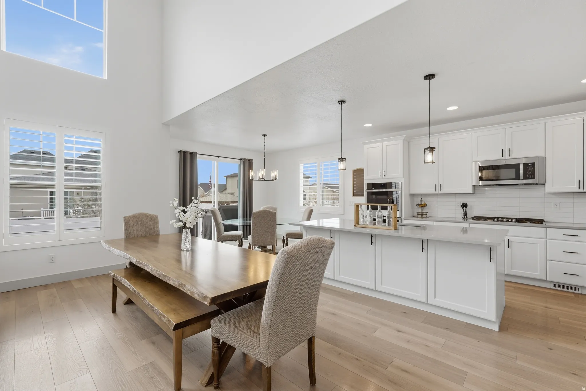 Dining area with light wood-style flooring, a chandelier, and plenty of natural light
