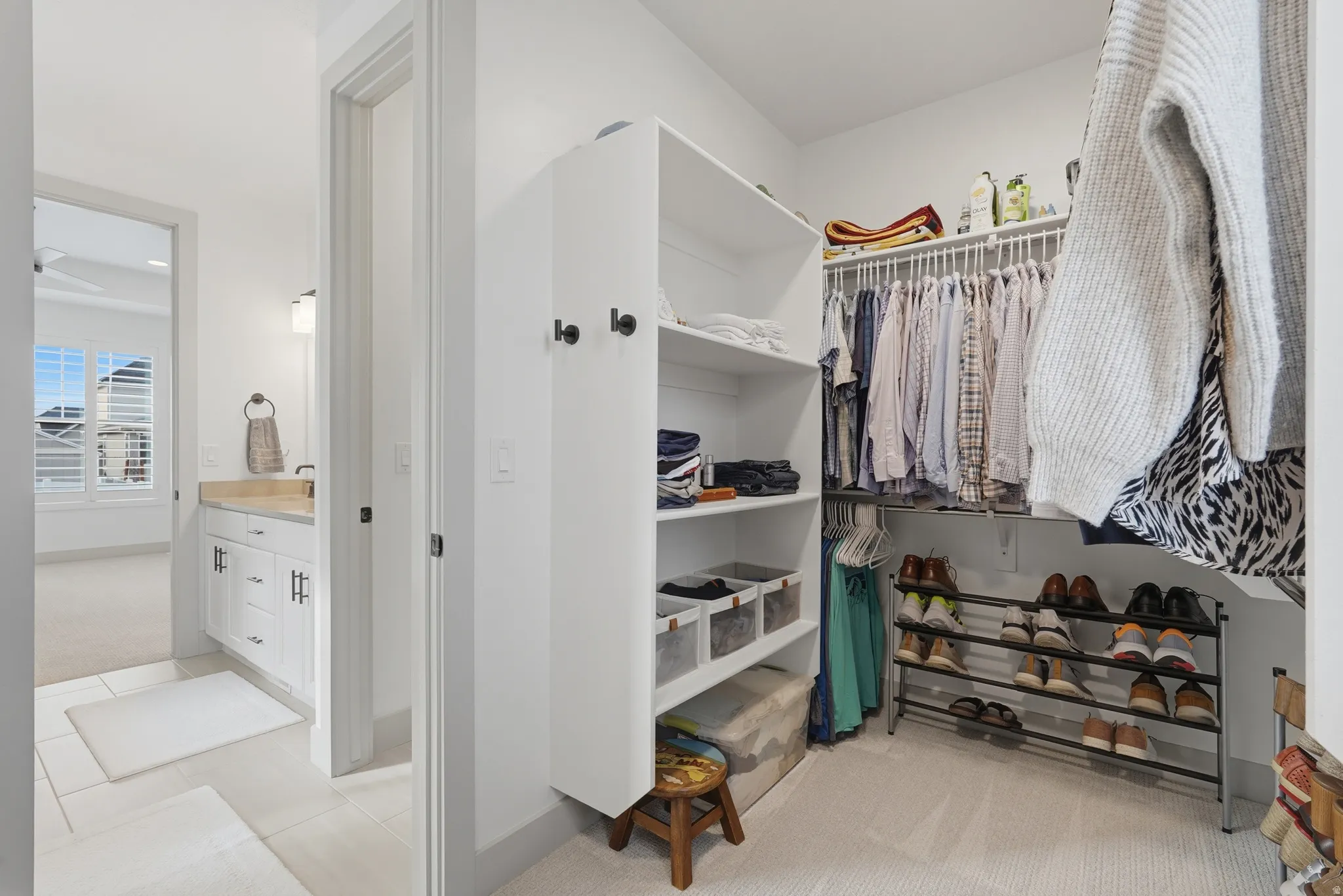 Walk in closet with light carpet and light tile patterned floors