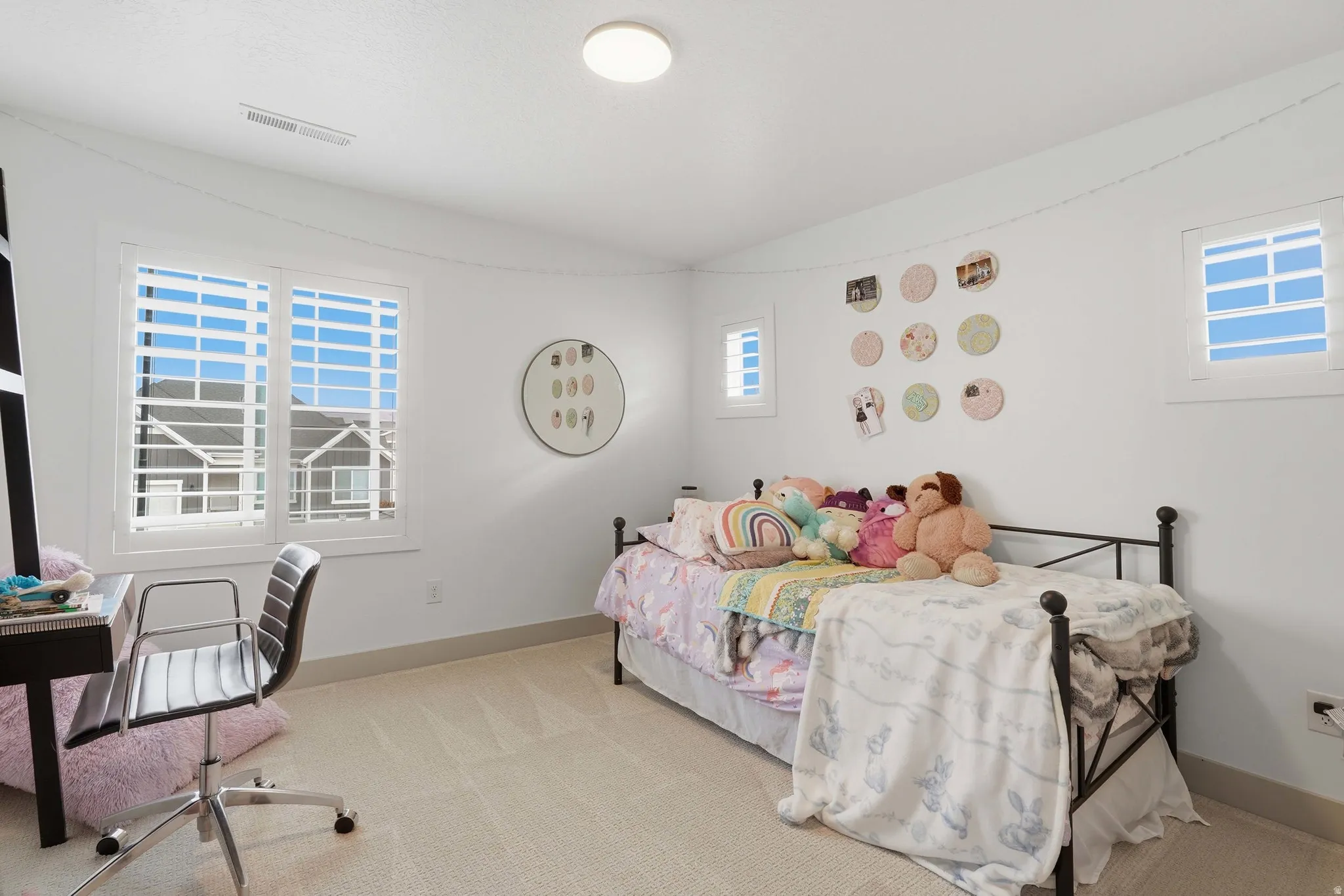 Bedroom featuring light carpet and multiple windows