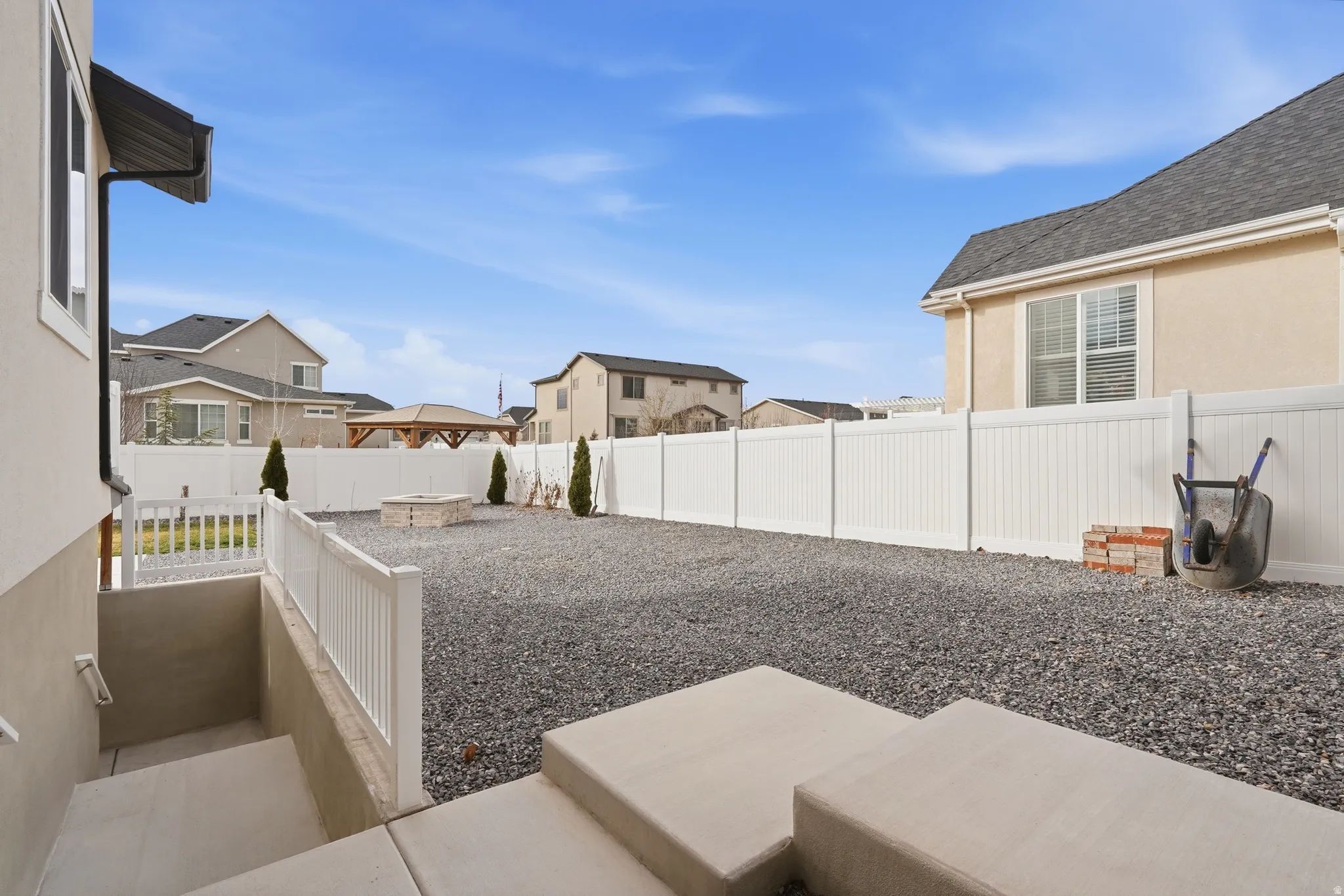 Fenced backyard featuring a residential view and a fire pit