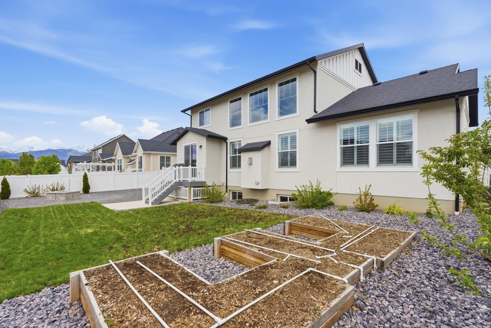 Back of house with a garden, stucco siding, and a mountain view