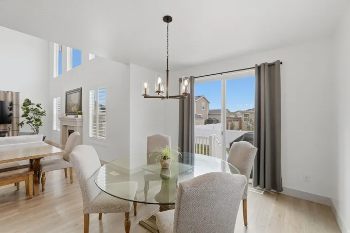 Dining area featuring a chandelier, light wood-style floors, plenty of natural light, and a fireplace