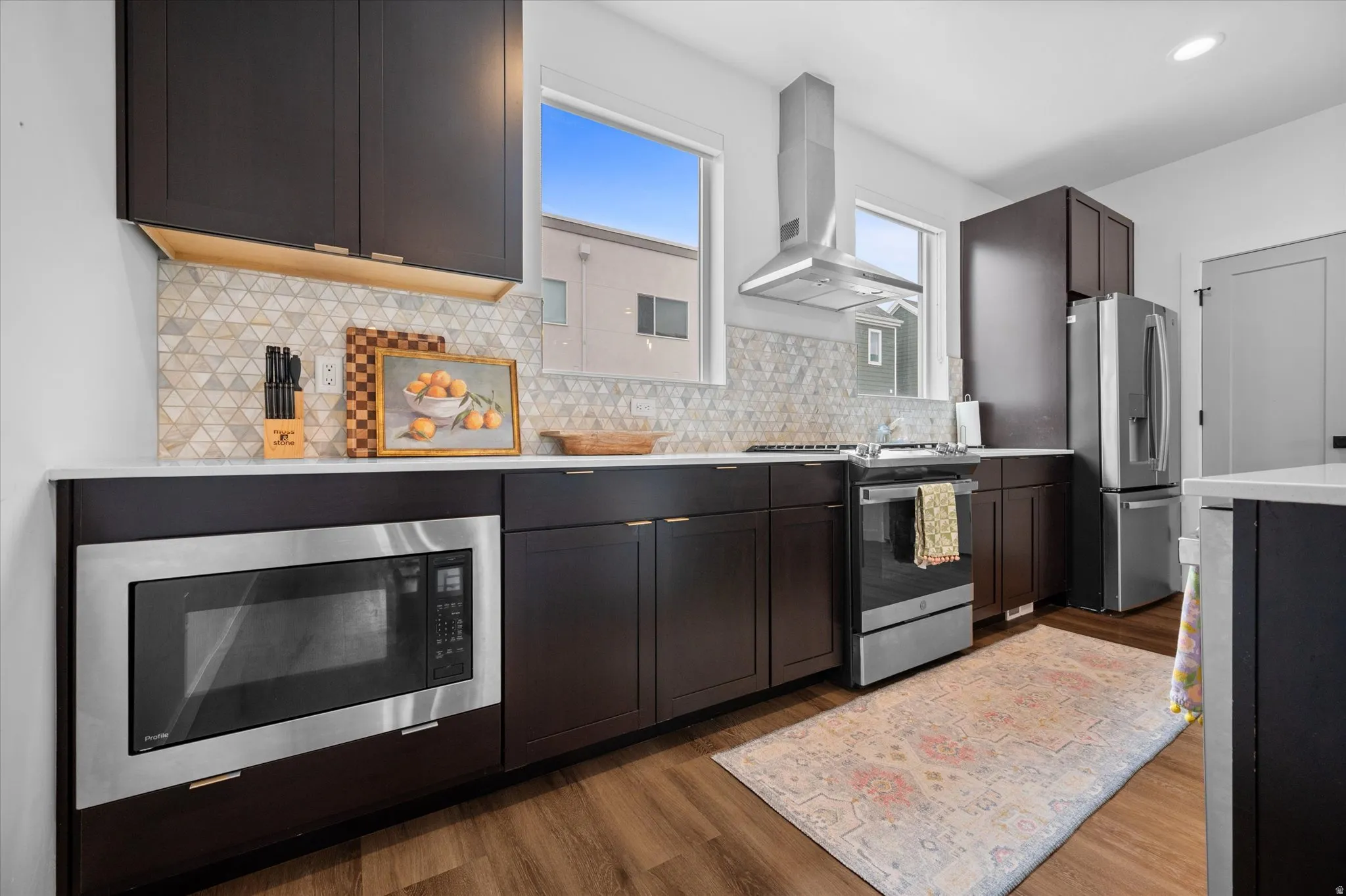 Perimeter quartz countertops with stainless steel hood, and northern windows for natural light.