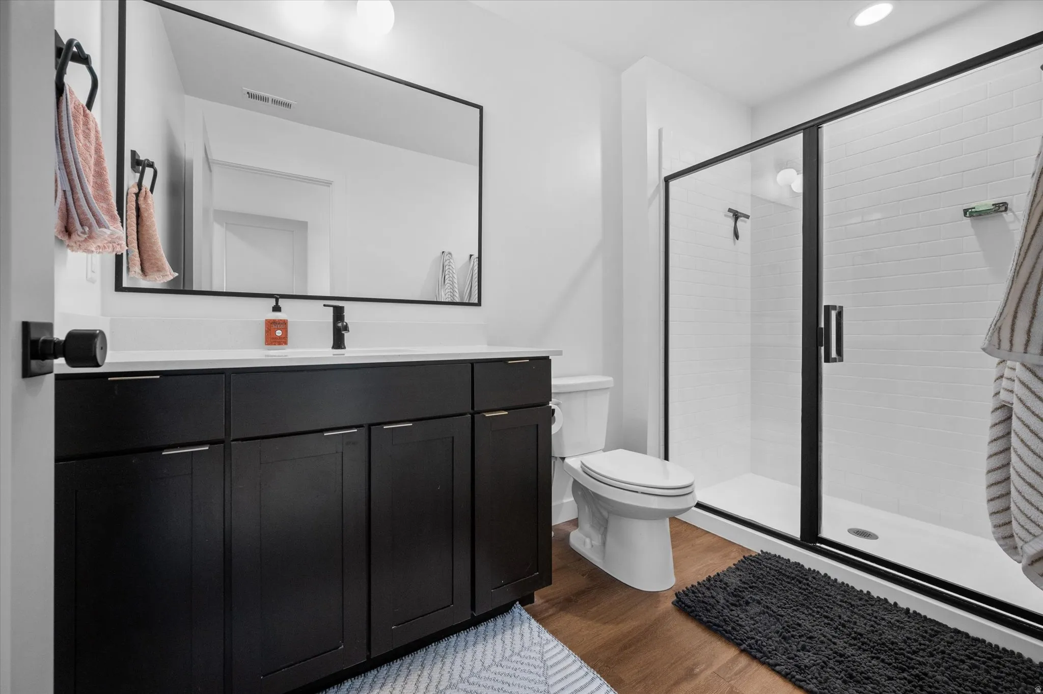 Full Owner's Suite bathroom featuring vanity with quartz countertops, shower, and LVP flooring.