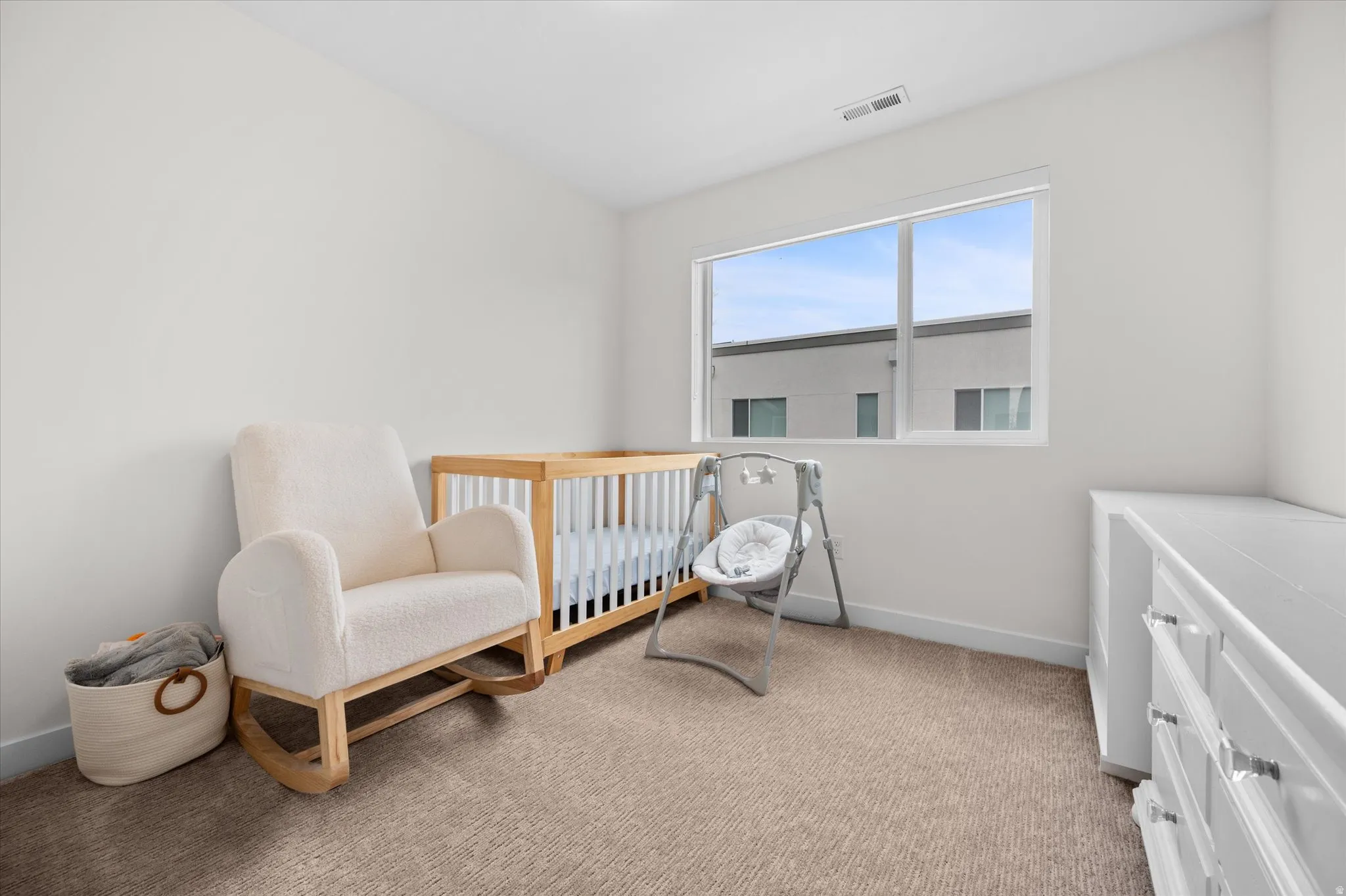 Bedroom with plush carpet, large window, and closet with built in shelving and cubbies.