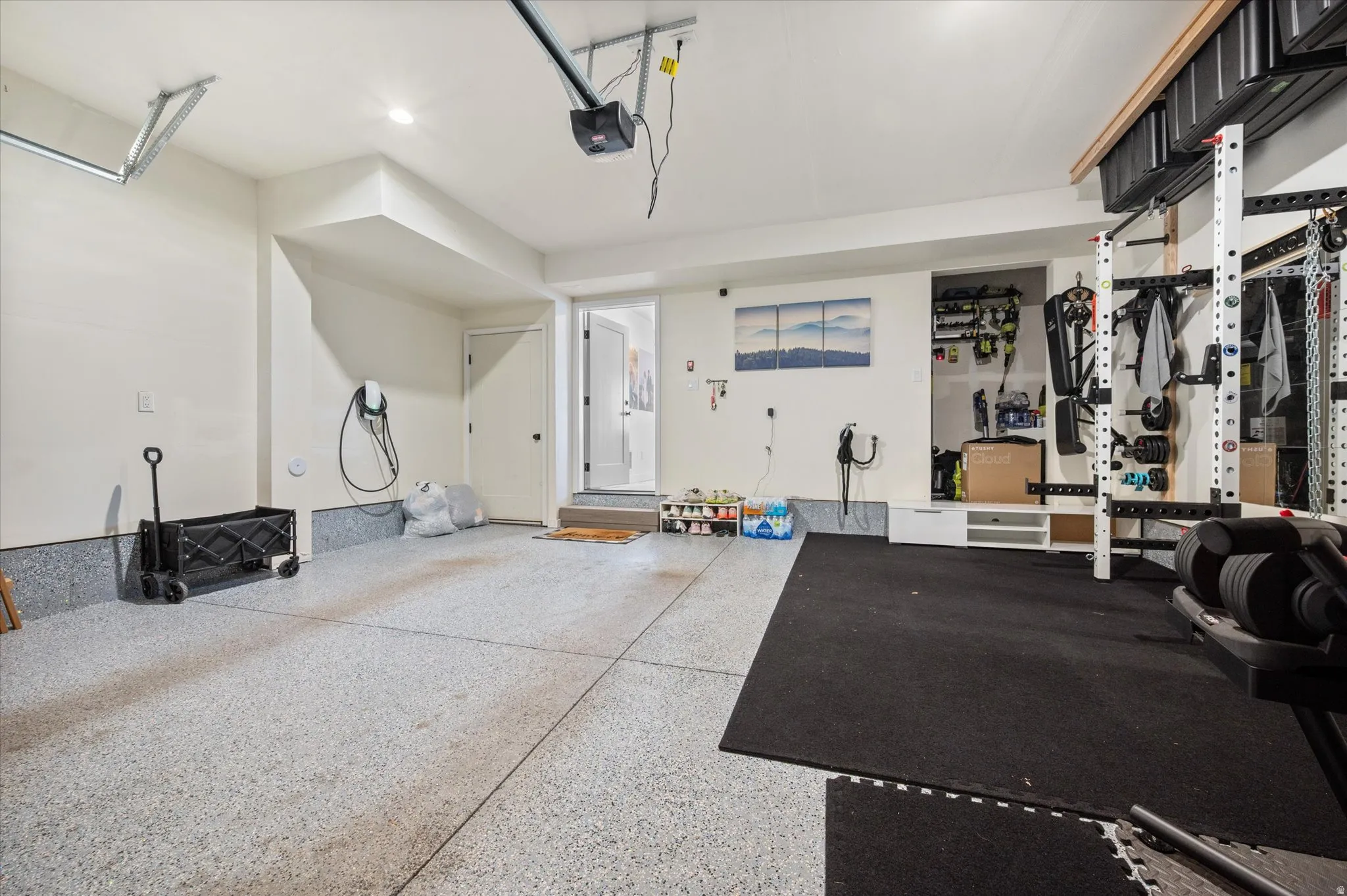 Garage with electric vehicle charger and epoxy floor.
