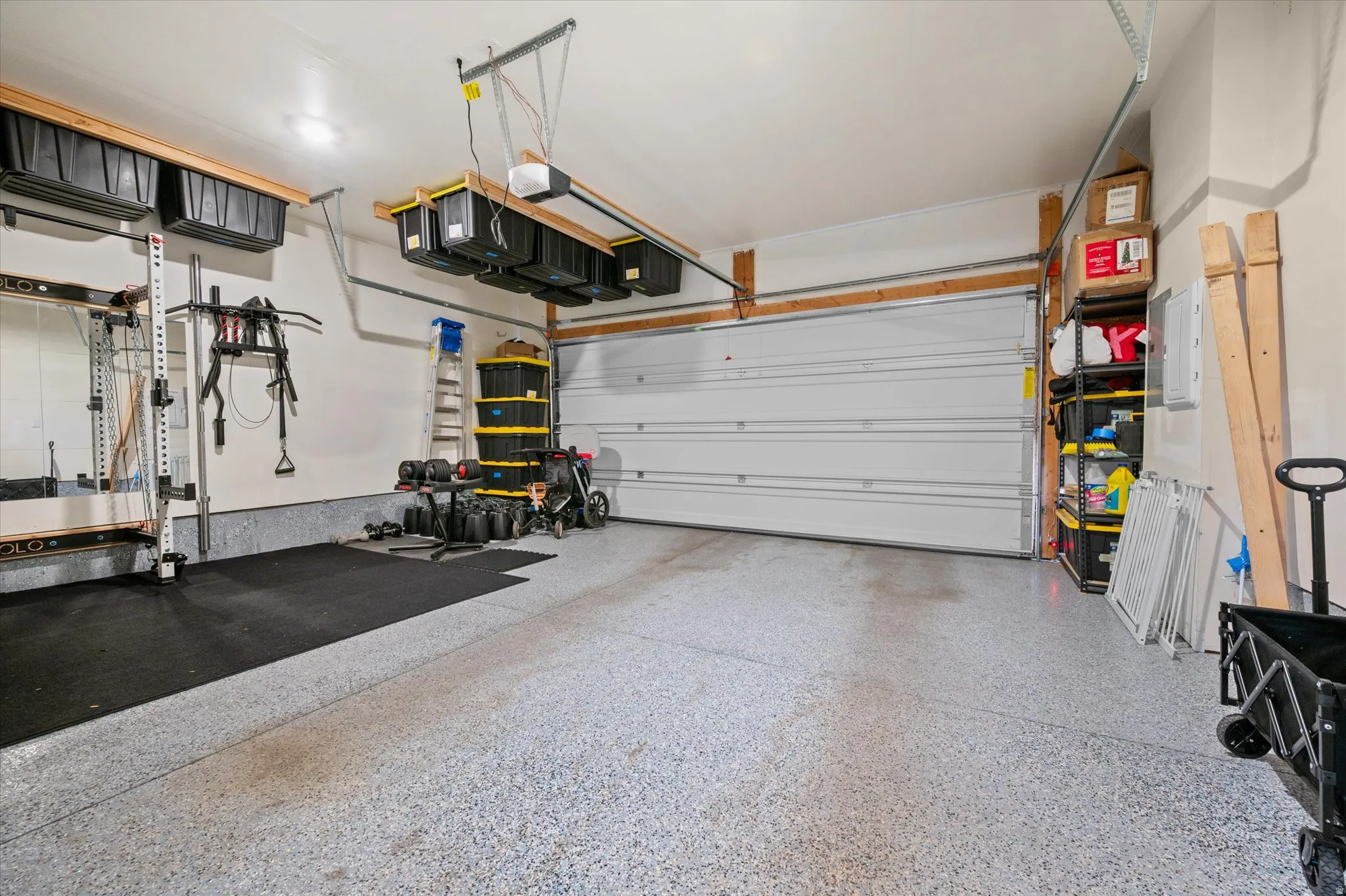 Garage featuring epoxy floor, custom shelving, and bin binders.