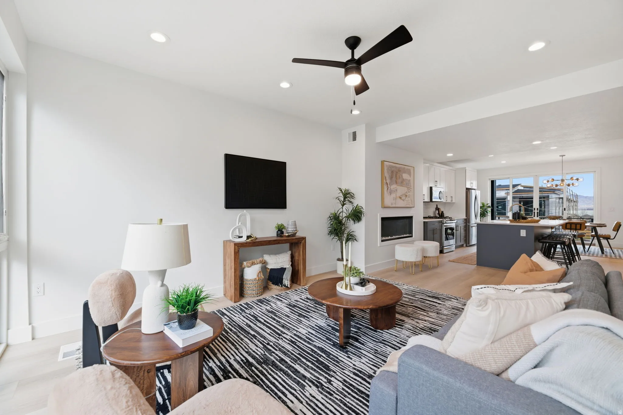 Living room featuring light wood finished floors, ceiling fan, and recessed lighting