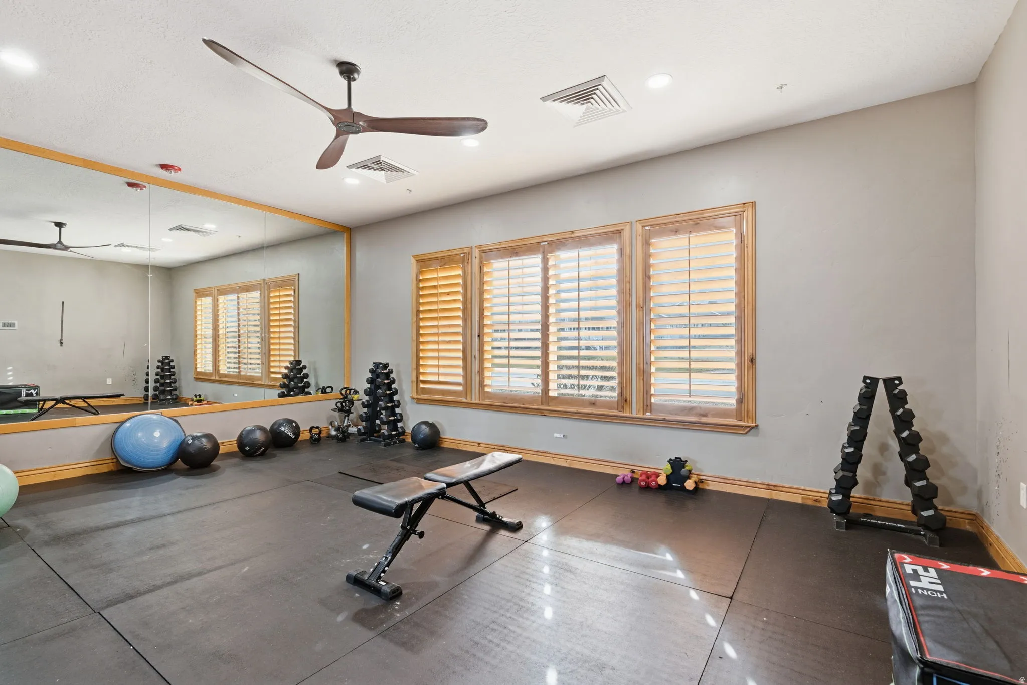 Workout area featuring ceiling fan and rubber floors