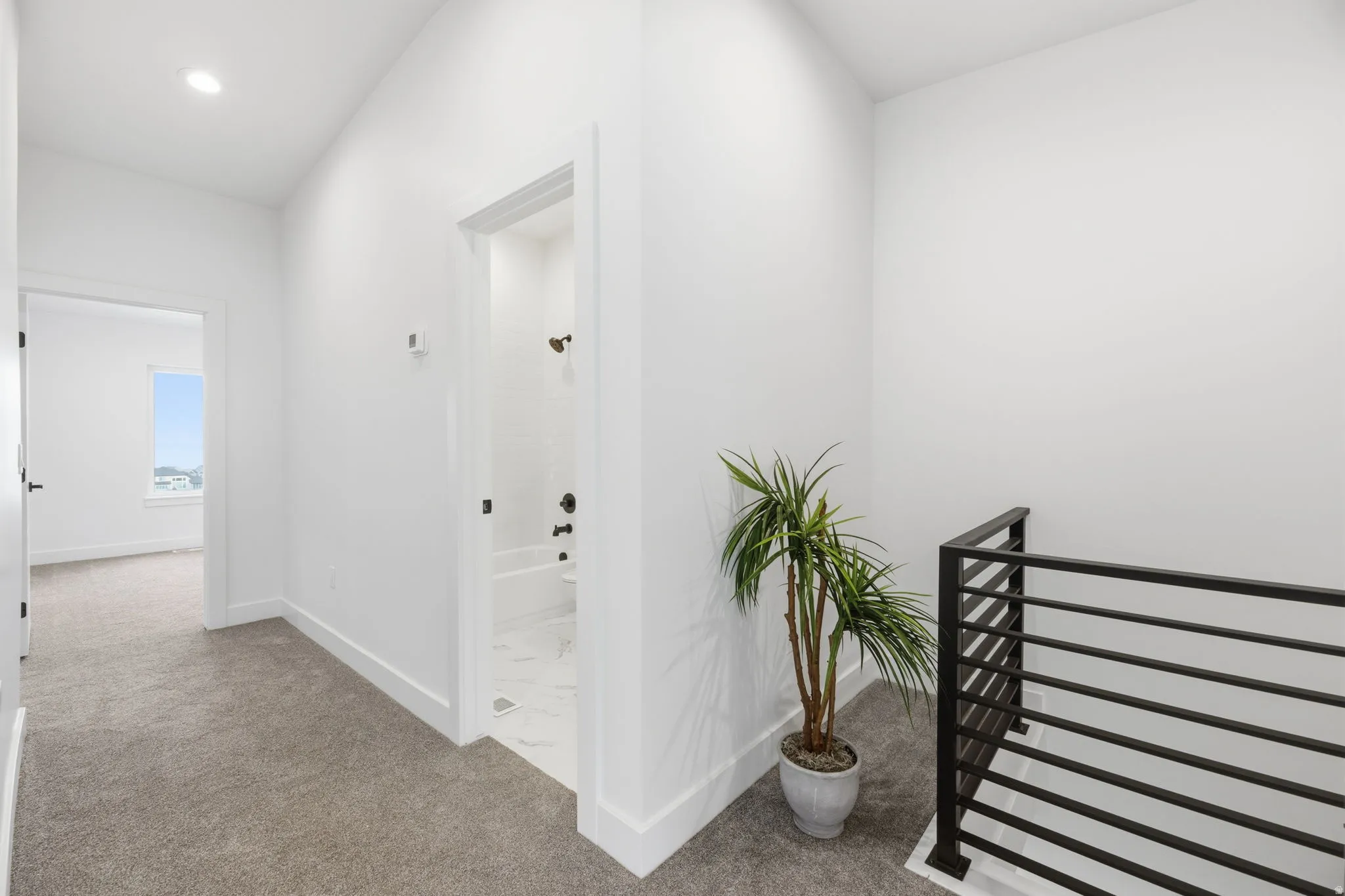 Hall with light carpet and vaulted ceiling