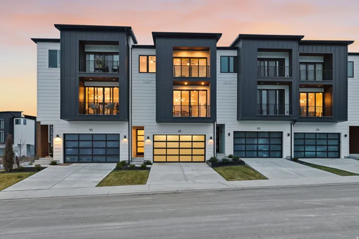 Modern home featuring a balcony, board and batten siding, concrete driveway, and a garage