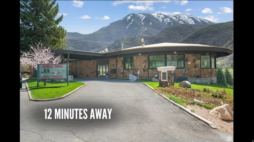 View of front facade featuring a mountain view, stone siding, and a front lawn