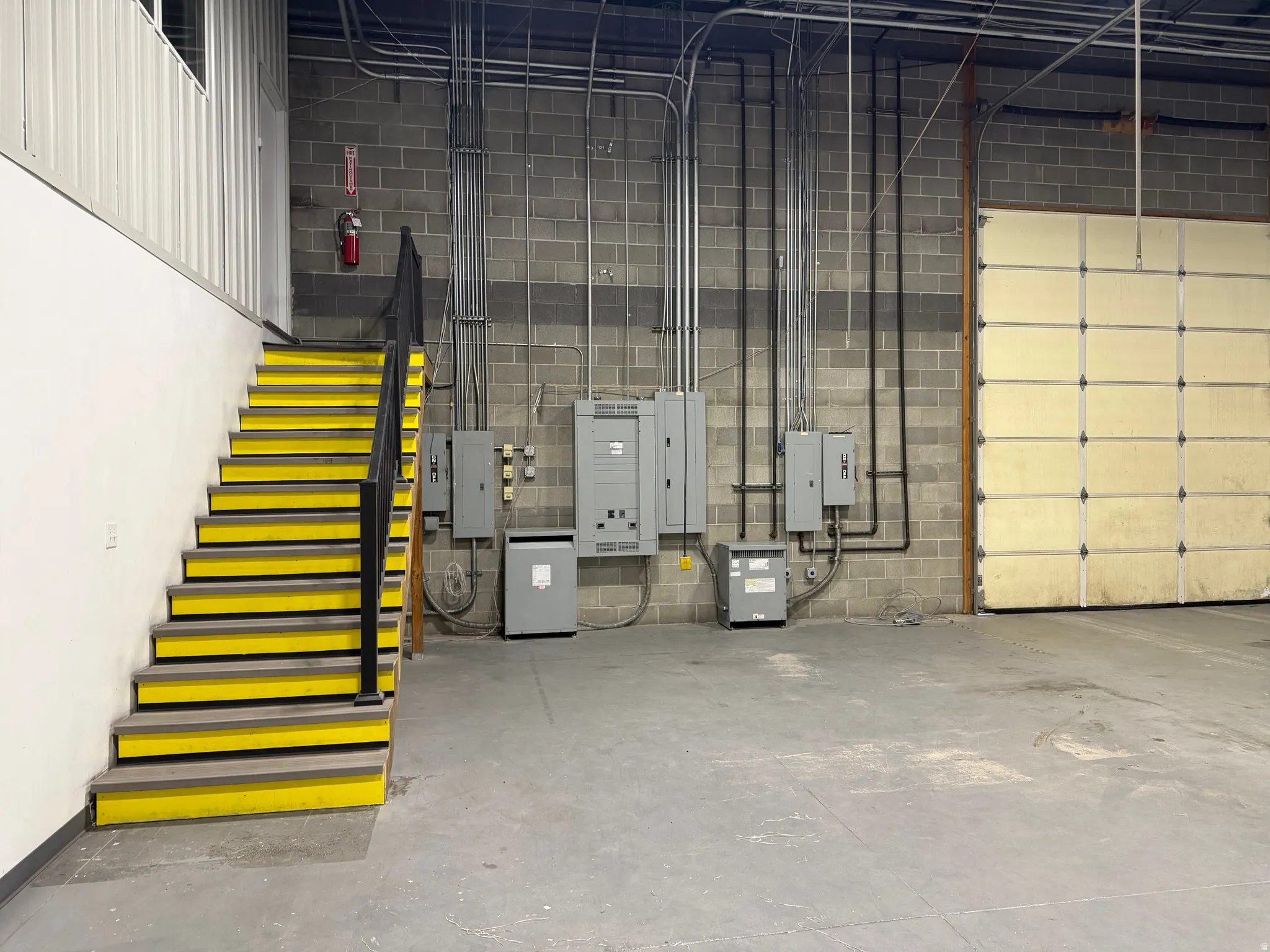 Garage with electric panel and concrete block wall