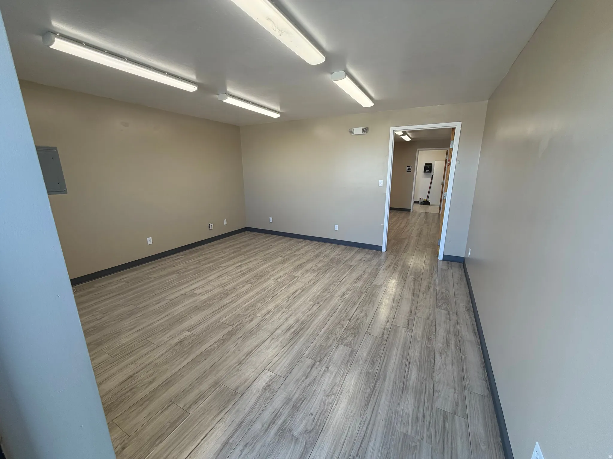 Unfurnished room with wood finished floors and electric panel