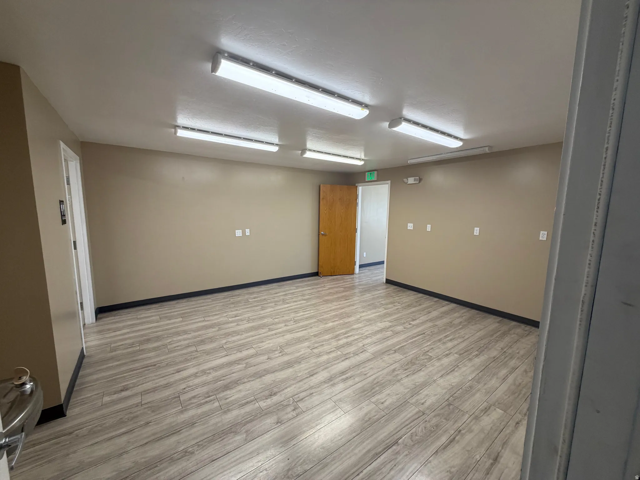 Spare room featuring light wood-style floors and baseboards