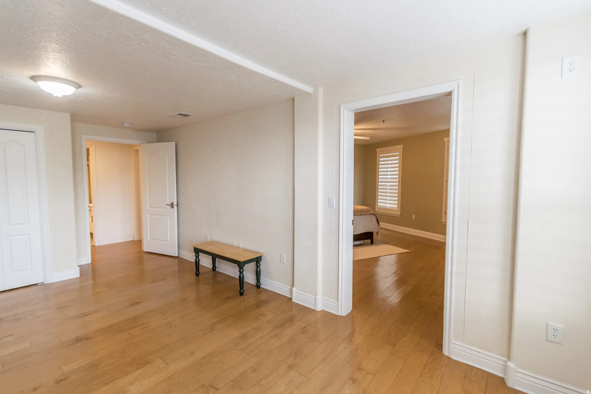 Spare room with a textured ceiling and light wood-style floors