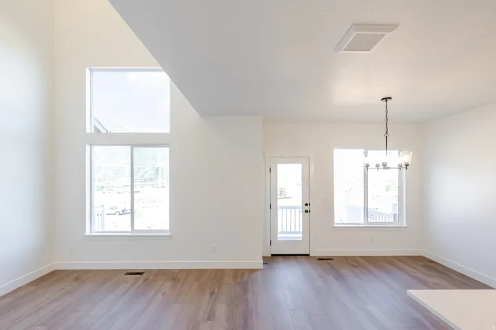 Spacious interior featuring a vaulted ceiling and stacked windows