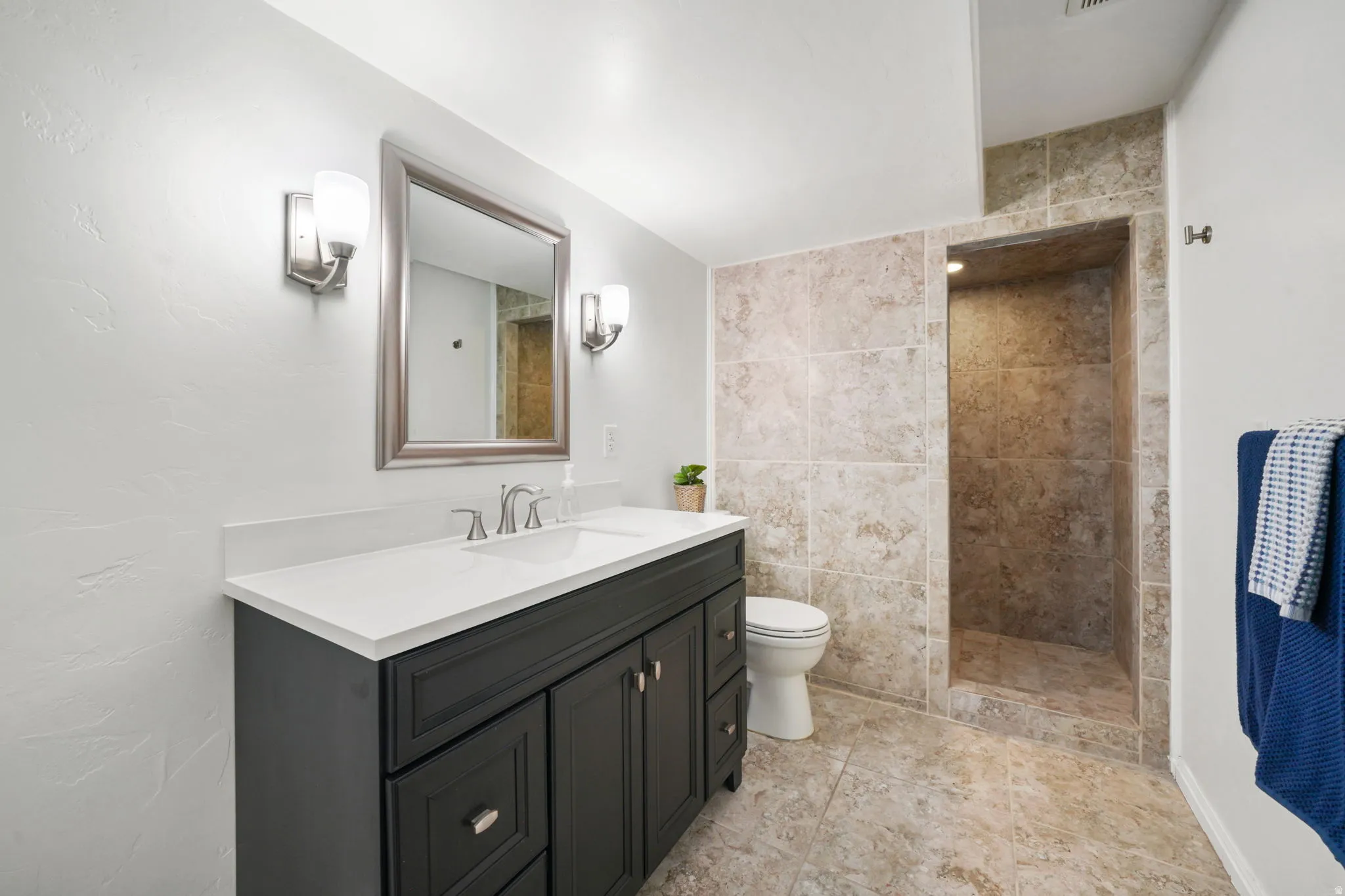 Full bathroom with vanity and tiled shower