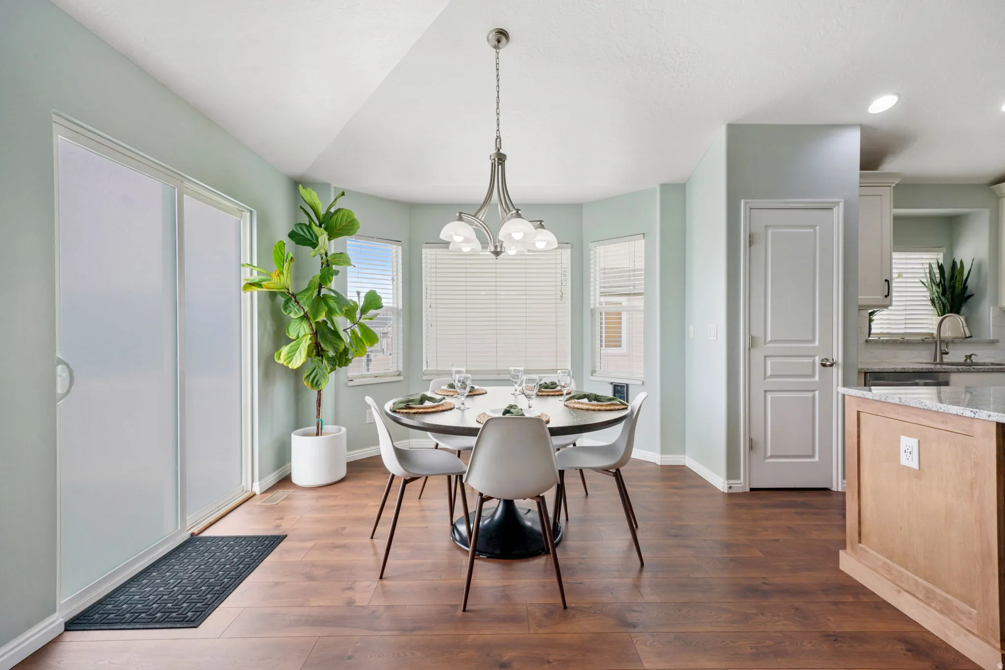 Dining room with dark wood-style flooring and suspended lighting