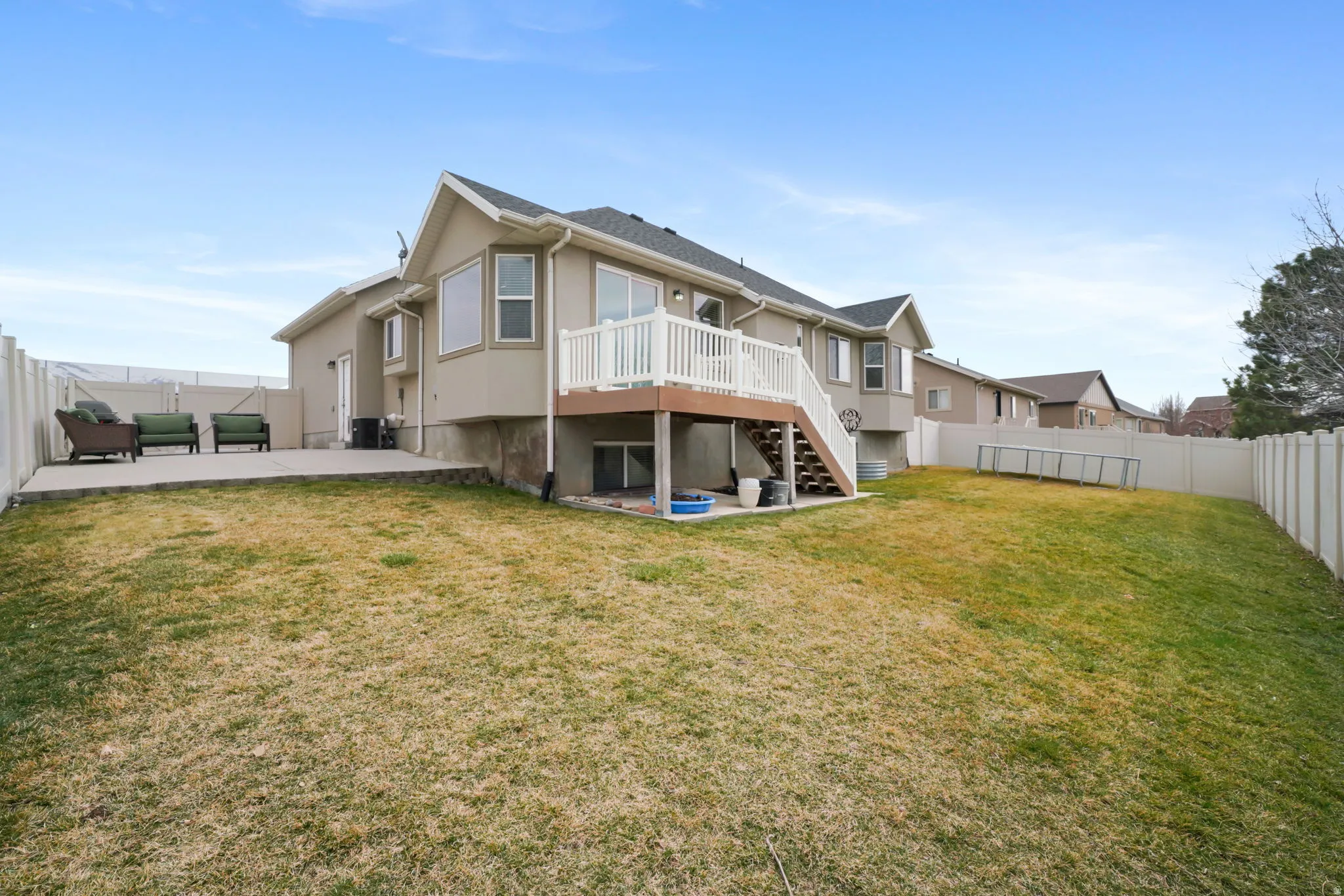 Rear view of house with a patio, a fenced backyard, a deck, and stucco siding