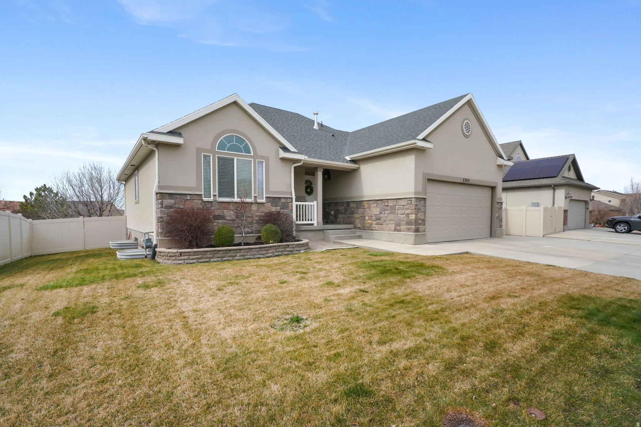 View of front of house featuring stucco siding, stone siding, an attached garage, and concrete driveway