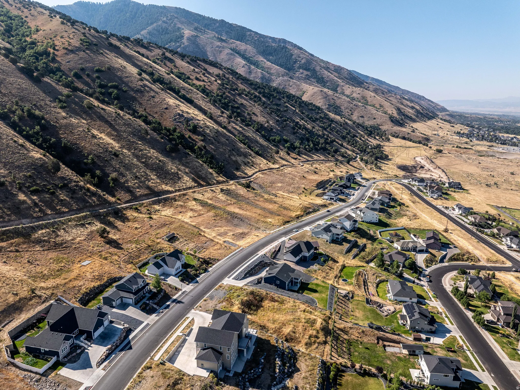 Aerial overview of property's location featuring mountains and nearby suburban area