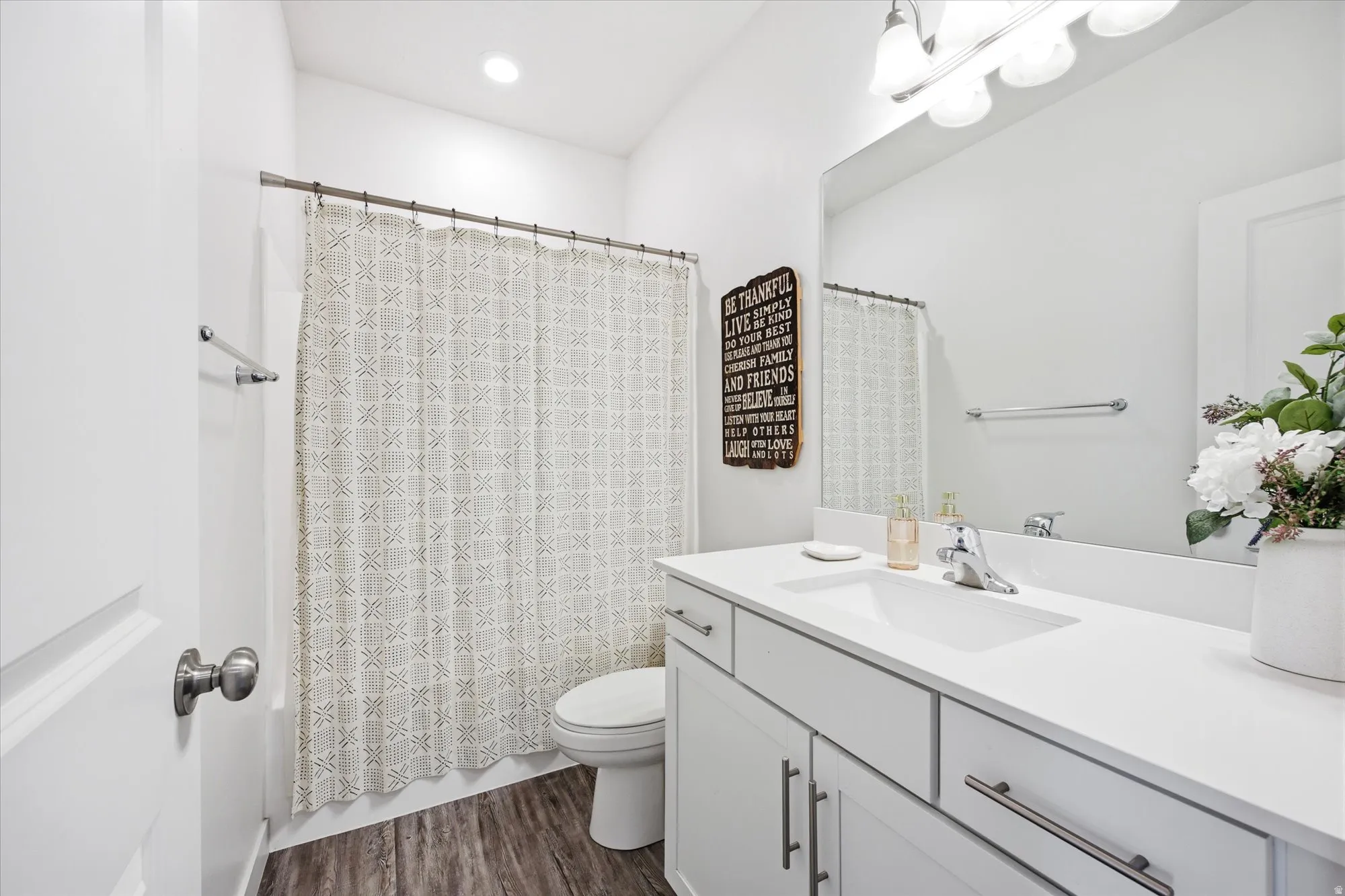 Full bath featuring vanity, dark wood finished floors, shower / tub combo, and recessed lighting