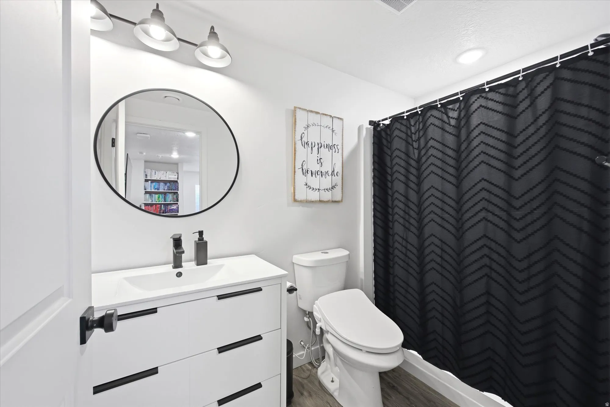 Bathroom featuring vanity, a shower with shower curtain, and wood finished floors