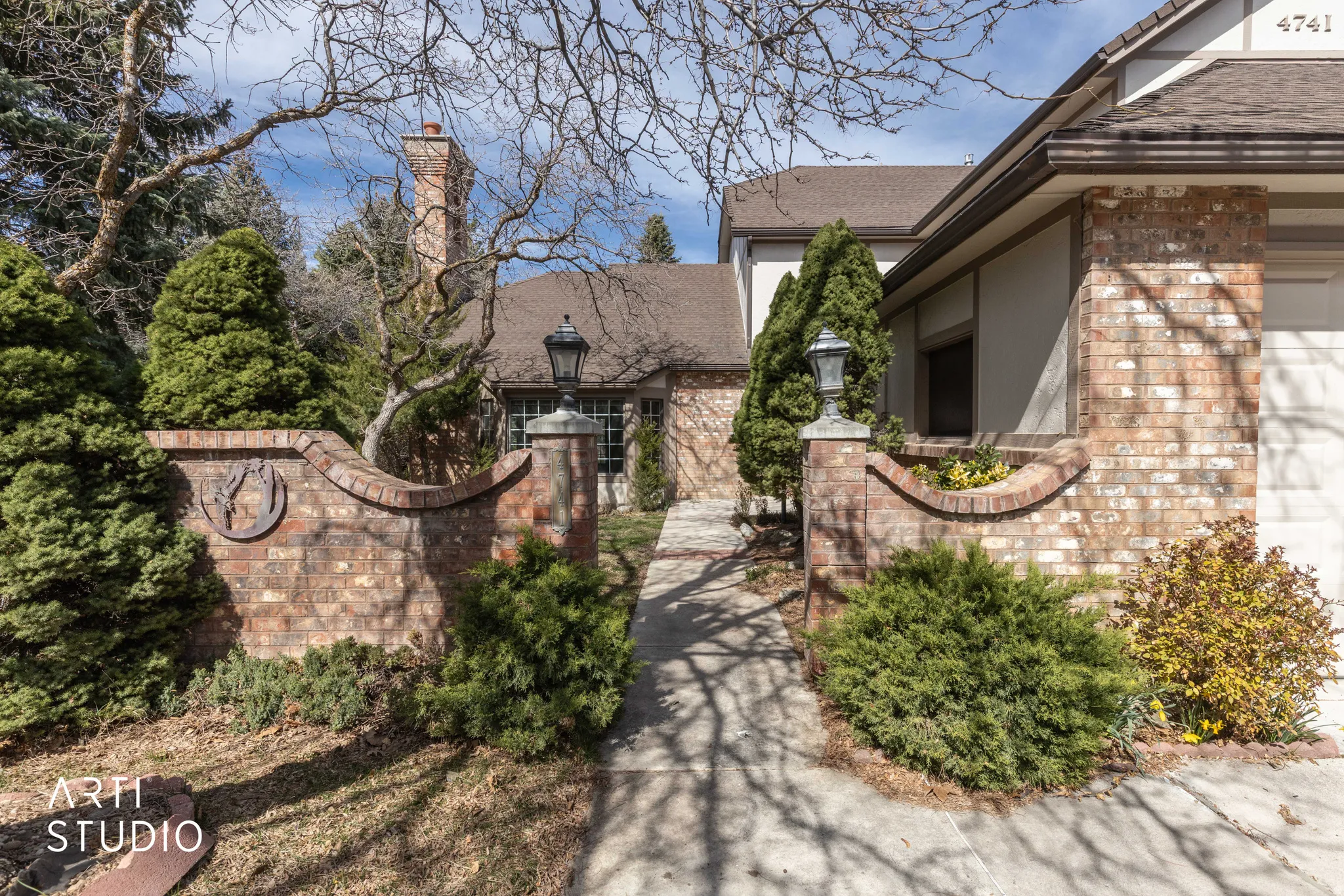 Exterior space with roof with shingles, brick siding, stucco siding, and a chimney